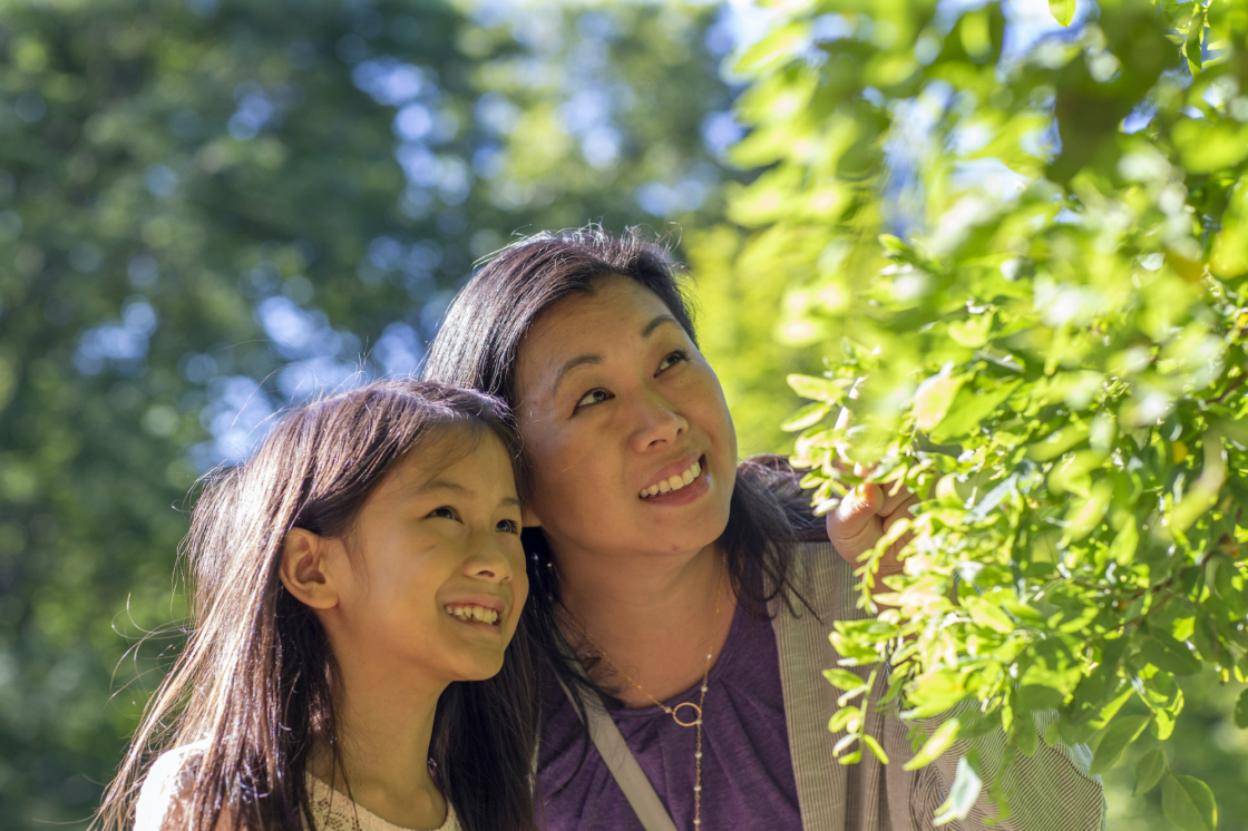 Mother and daughter look at leaves together